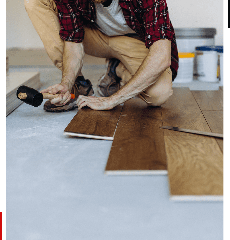 Worker installing wooden flooring with mallet