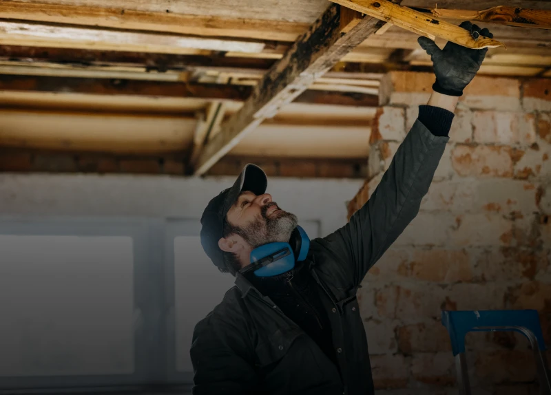Construction worker checking roof beams