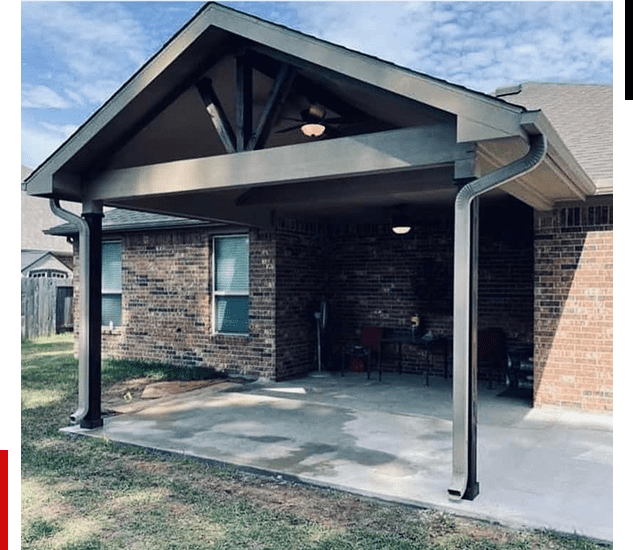 Covered patio with brick walls and wooden beams on a sunny day.