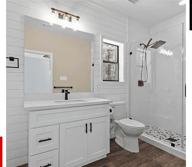 Modern white bathroom with vanity, toilet, and walk-in shower.